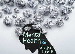 A graphic with the text "Mental Health and Sight Loss" in large mint green and teal lettering overlaid on a black silhouette of a human head in profile. Dozens of crumpled balls of paper covered in printed words float above and around the silhouette, representing the mental noise and overwhelm associated with anxiety and stress.