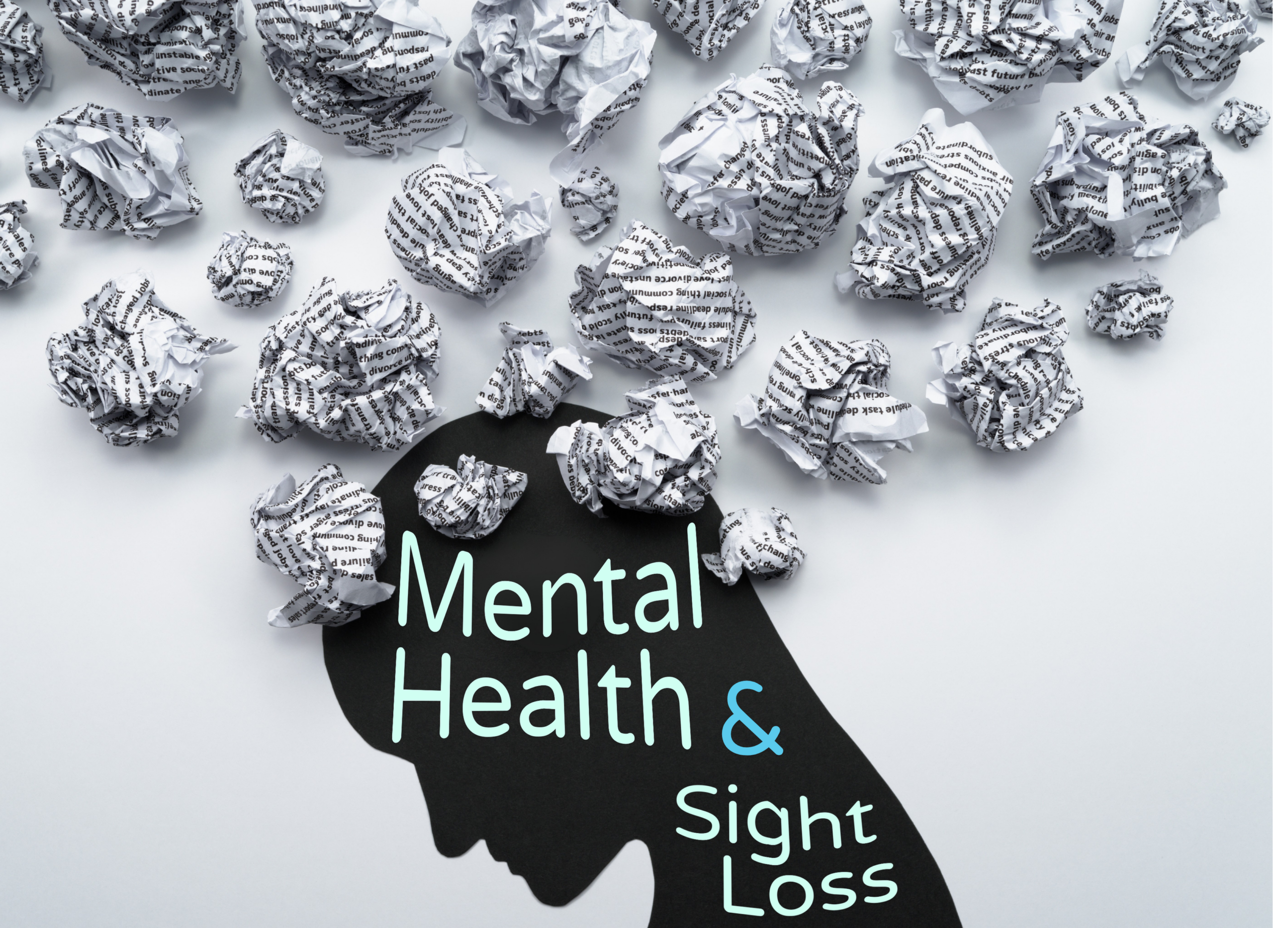 A graphic with the text "Mental Health and Sight Loss" in large mint green and teal lettering overlaid on a black silhouette of a human head in profile. Dozens of crumpled balls of paper covered in printed words float above and around the silhouette, representing the mental noise and overwhelm associated with anxiety and stress.